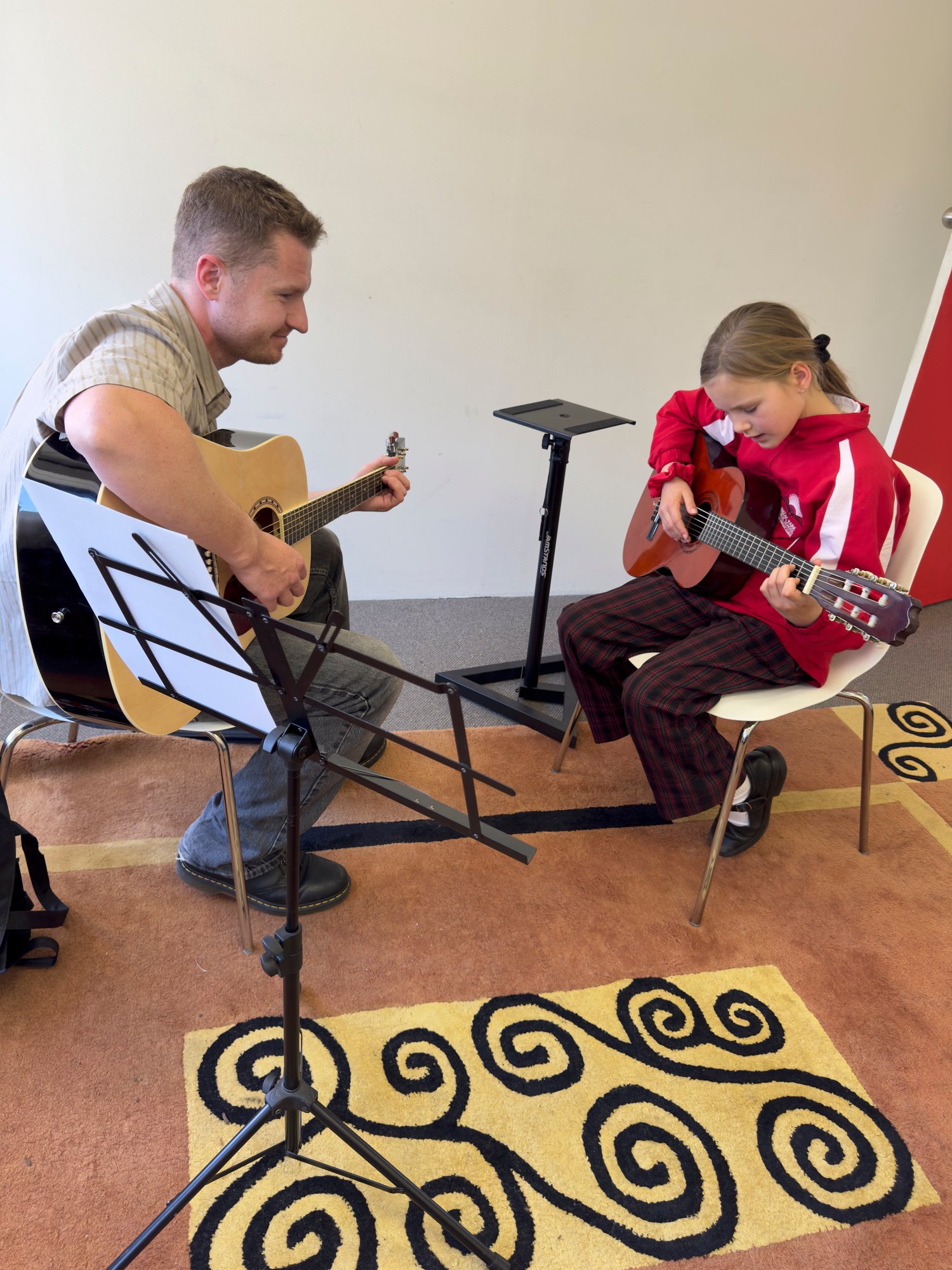 Tutor Ollie Teaching Guitar to Student